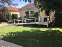 man in wheelchair see his new aluminum wheelchair ramp in front of long beach CA home
